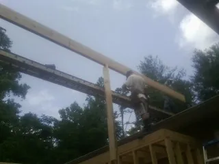 Carpenter setting a ridge beam over a new addition frame — Ice Dam Removal by Roofing Brothers in Amargosa Valley
