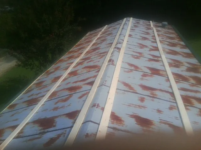 Rusted metal roof panels with new wood purlins before replacement — Storm Damage Roof Repair in Amargosa Valley by Roofing Brothers