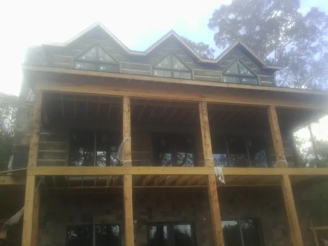 Dormers and porch framing on a large log home under construction — Roof Coating work by our crew in Amargosa Valley