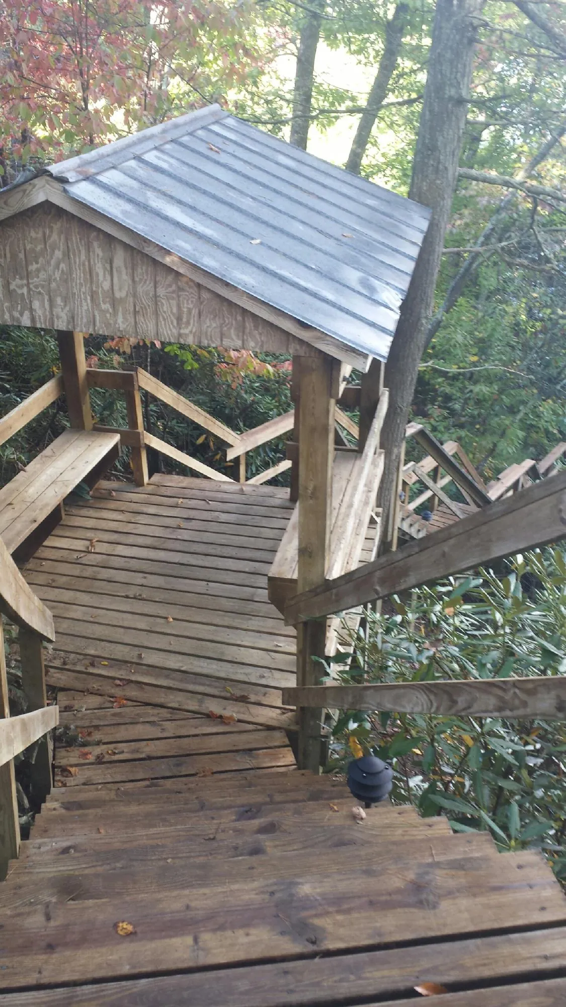 Metal roofed shelter over wooden steps on a wooded walkway — Skylight Repair & Installation work by our crew in Amargosa Valley